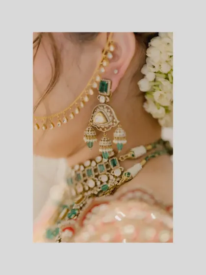 A detailed shot of the bride's jewelry, focusing on her beautiful emerald earrings and necklace.