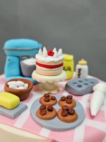 A close-up of the miniature baking elements on the floating tier of the baker-themed anti-gravity cake.