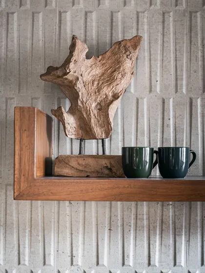 Here, one of my driftwood-inspired artifacts is styled on a floating teak shelf. It serves as a beautiful focal point, adding a sculptural element to the wall.