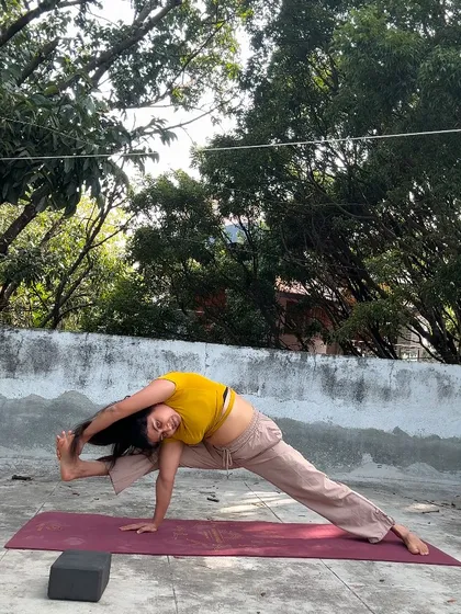 A challenging balancing pose, Visvamitrasana, practiced outdoors. This asana requires open hips, flexible hamstrings, and a strong core.