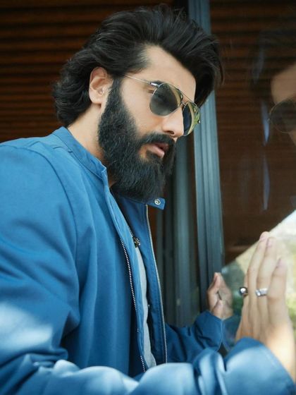 A candid, reflective moment captured during the Exhibit Magazine shoot with Arjun Kapoor. The blue Paul Smith jacket adds a pop of color, showing a softer side to the editorial's narrative.