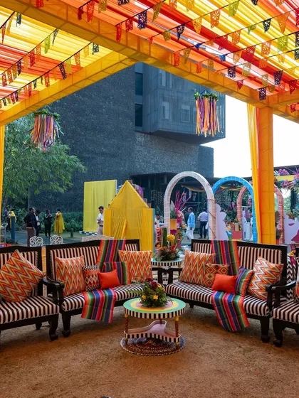 The vibrant seating area for a carnival-themed event, with striped and patterned cushions, colorful overhead draping, and a cheerful, festive atmosphere.
