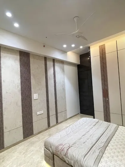 A view of the room from the side, showing the extensive wall paneling and integrated wardrobe design. The consistent use of materials creates a harmonious and seamless look.