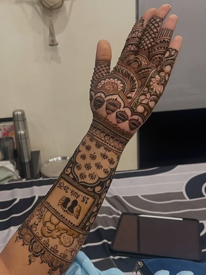 A side view showcasing the personalized elements on the forearm. The wedding date and couple's silhouette are clearly visible, integrated with traditional Indian patterns.