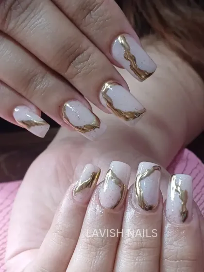 A unique abstract design with thick, textured gold chrome accents on sheer, shimmery square nails.