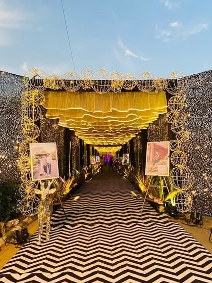 A glamorous and modern entrance design. We flanked the walkway with full-height silver sequin panels and used a chevron-patterned carpet, creating a chic and dazzling first impression.