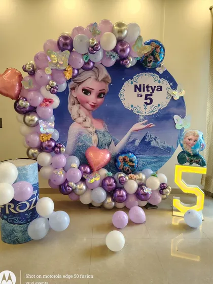A closer view of the Frozen-themed birthday decoration, highlighting the balloon details and the Elsa character on the backdrop.