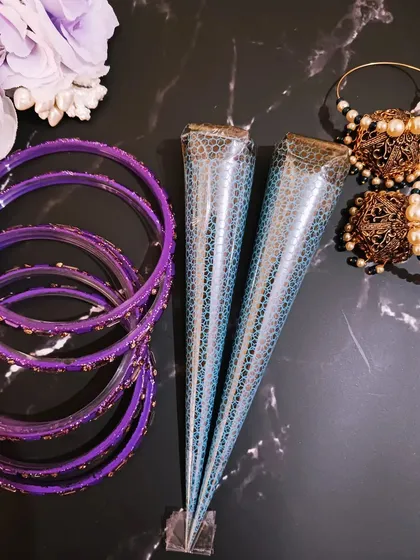 My handmade organic henna cones are available for purchase, perfect for artists and henna lovers. They are pictured here with some festive bangles and earrings, ready for any celebration.