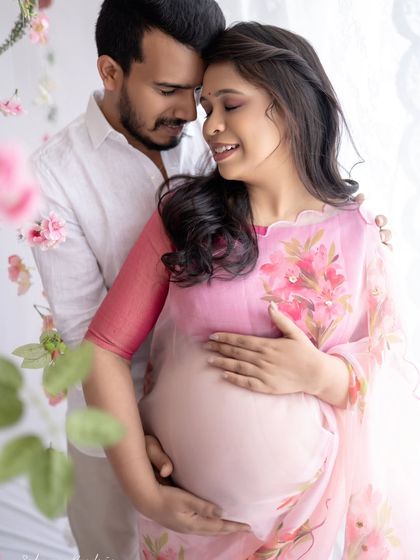 An intimate close-up of the couple. The soft lighting and their gentle expressions make this a wonderfully romantic and tender maternity photograph.