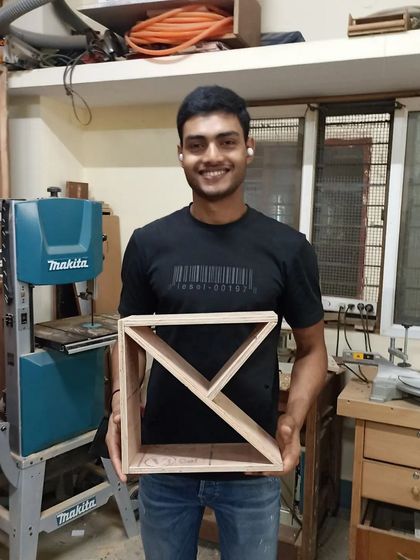 An interior design student with the geometric shelf he designed and built. This kind of project is a great way to explore form and function.