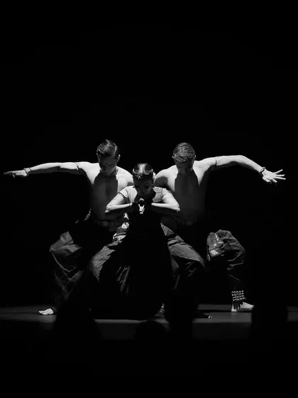 A low-light, high-contrast shot from 'Abha'. This style of photography captures the dramatic and sculptural quality of the dancers' poses.
