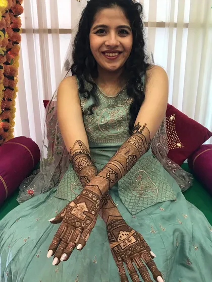 A smiling bride, happy with her intricate full-hand mehndi. Seeing this joy is the best part of my work.