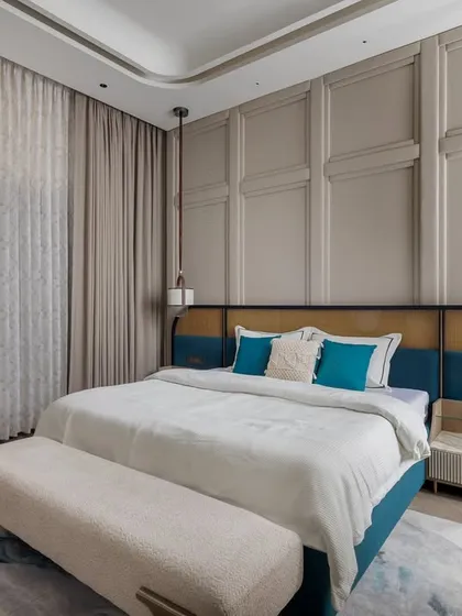 We designed this daughter's bedroom with a soothing palette of beige and pops of vibrant teal. The custom bed features a unique headboard combining teal velvet with natural cane, set against a classic paneled wall.