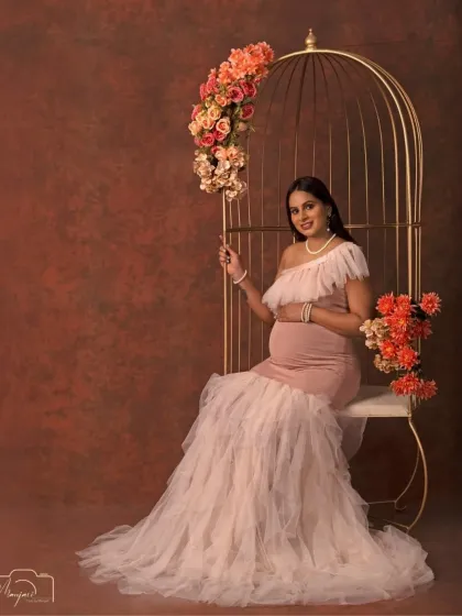 A portrait of pure elegance. This mama-to-be looks like a queen seated in our golden cage chair, adorned with beautiful flowers.