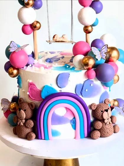 Another detail shot of the swing baby shower cake, showing the cute teddy bears and the pastel rainbow.