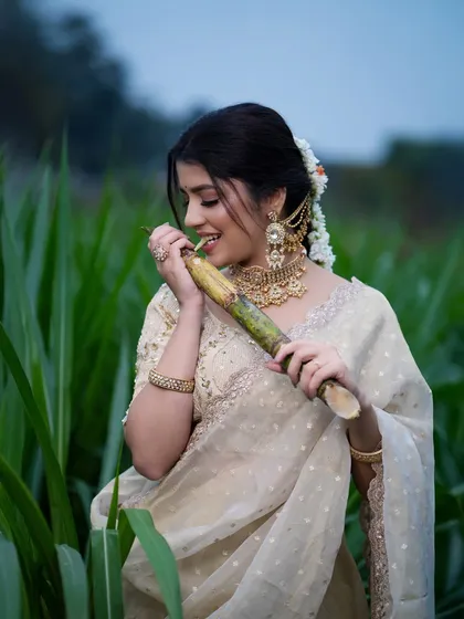 A candid photo of the model playfully biting into a piece of sugarcane, a classic symbol of the Sankranti celebration.