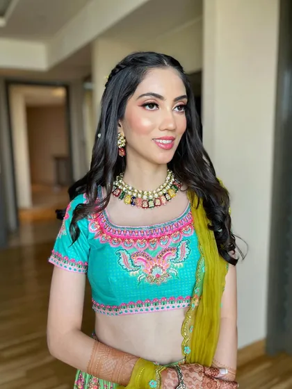Balancing a colorful Mehendi outfit with the perfect soft glam look for Chaitali. The makeup is kept fresh and radiant.