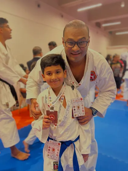 A proud instructor with a young student holding his medal and certificate. Every achievement is a step forward on the path of Karate-do.