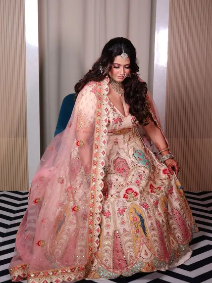 A seated portrait of the plus-size bride, showing the beautiful flare of her lehenga. The colors and details are simply stunning.
