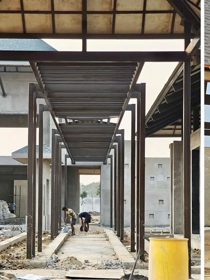 The developing walkway and structural frame of the Bhubaneswar villa. This image shows the careful planning of circulation and space, with the metal framework defining the future corridors that will connect the different zones of this luxury farmhouse.