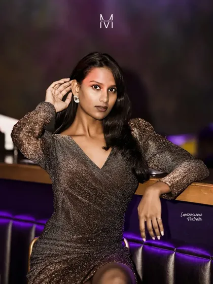 A direct and engaging portrait, the model looks at the camera with a confident expression, perfectly at home in the stylish club setting.