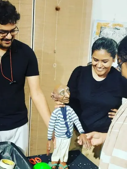 Participants of our workshop gather around to inspect the 'Popo' puppet after the demonstration.