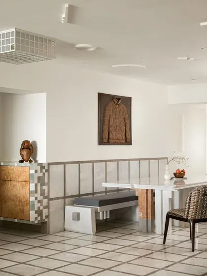 This dining space is a study in geometry and craft. The custom dining table is made of solid stone, with playful, colourful marble inlays. It is paired with a sculpted stone bench, turning everyday meals into a design-led ritual.