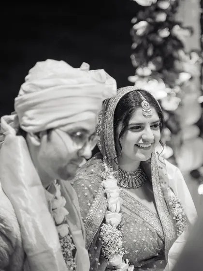 A quiet, smiling moment between the couple during their ceremony, captured in timeless black and white.