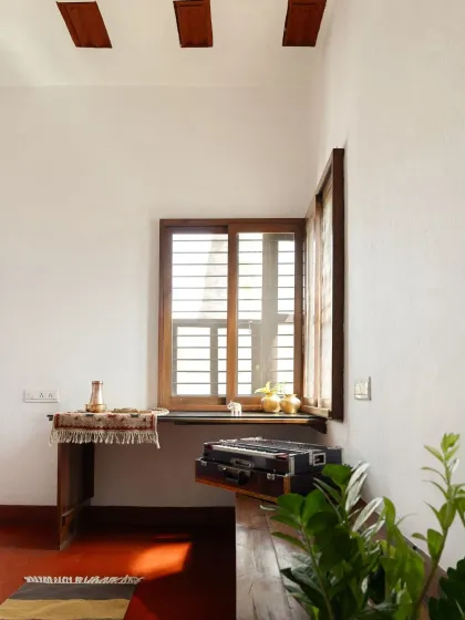 A small study nook carved out by a window, demonstrating how every inch of the narrow home is utilized. The design is simple, functional, and deeply rooted in its context.