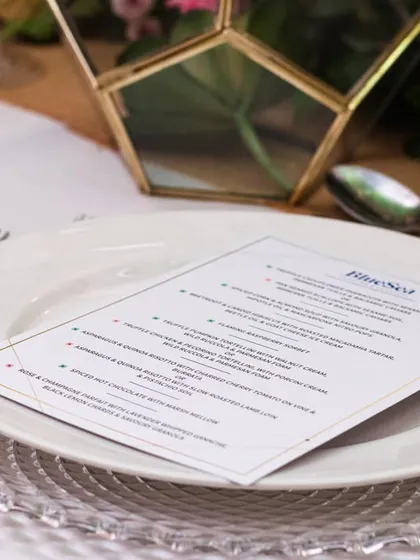 A personalised menu resting on a silver charger plate. At our venues, every detail of the tablescape is thoughtfully considered to align with your event's theme and vision.