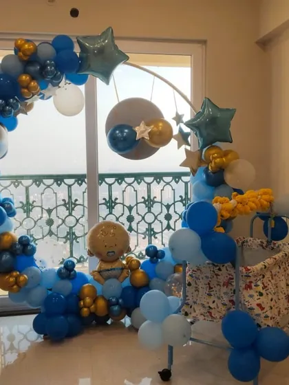 A celestial-themed welcome for a baby boy. This setup features a circular frame decorated with a blue, gold, and white balloon arch, complete with star-shaped foil balloons.