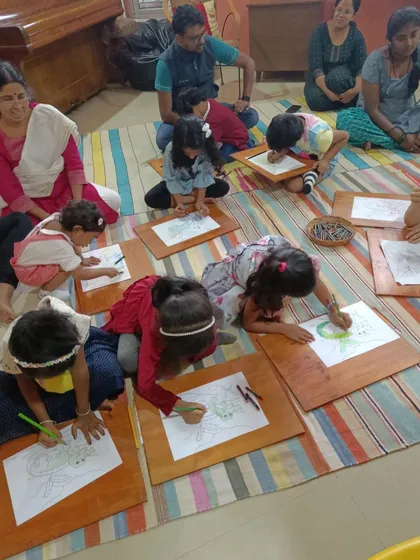 Children lie on the floor to get the perfect angle for their drawings of a ghariyal. We encourage them to get comfortable and be creative.