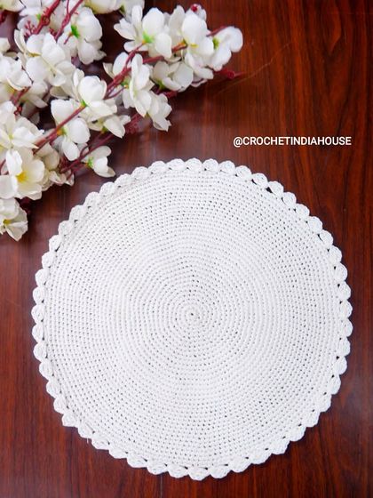 A simple yet elegant round white table mat with a scalloped edge. This classic design is available in any color and is perfect for any occasion.