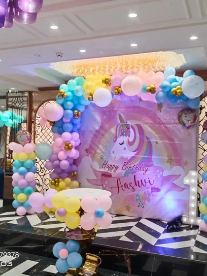 This angle shows the beautiful pastel colors and details of the unicorn birthday decoration, perfect for a little one's special day.
