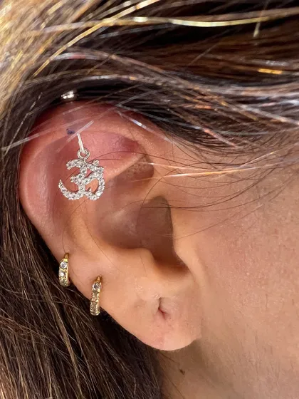 A sparkling Om hanging from the helix, paired with simple gold hoops. This is a beautiful way to express your spirituality with style.