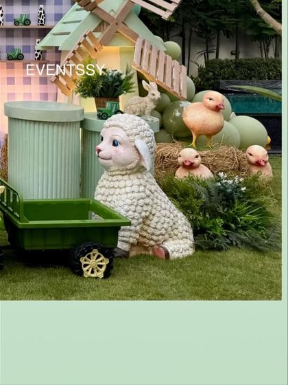 A fluffy sheep prop surrounded by little chicks on hay, adding to the adorable farm scene.