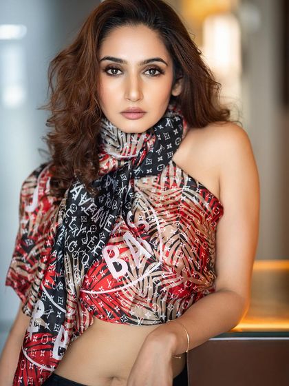 A creative studio shot of Ragini Dwivedi for a magazine's birthday edition. The use of a patterned scarf as a top creates a dynamic and visually interesting portrait.