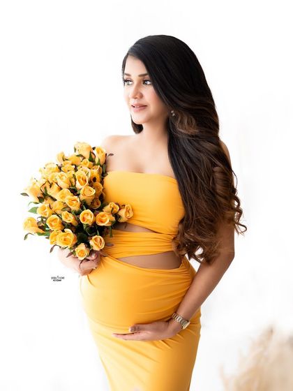 A close-up portrait with a bouquet of yellow roses. The color coordination is just perfect and she looks so happy.