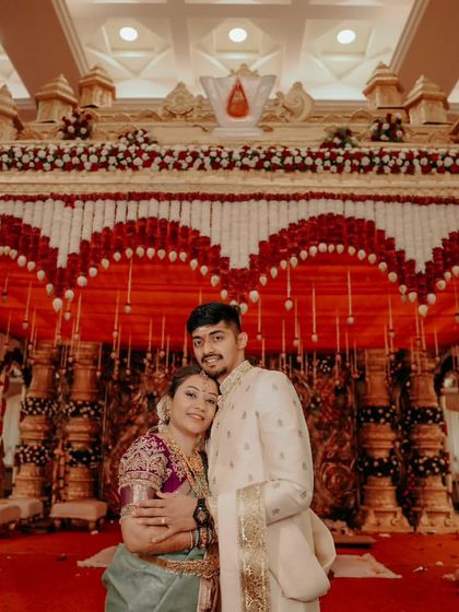 A wide shot of the couple on the beautifully decorated wedding stage, capturing the grandeur of the event.