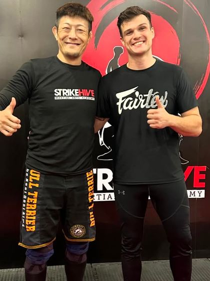Our coach stands with a BJJ Black Belt from Japan after a seminar, a testament to our commitment to global martial arts collaboration.