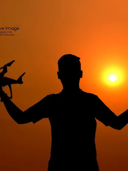 A creative silhouette I captured against a vibrant sunset, holding both my drone and my camera. This image represents my passion for both aerial and ground photography, blending artistry with technical skill.