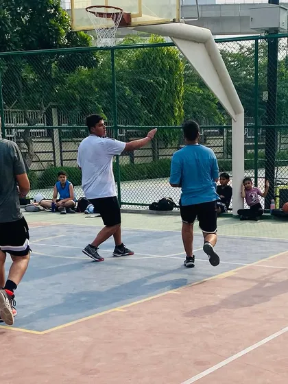 A coach directs players during a game, pointing out defensive assignments. In-game coaching is crucial for development.