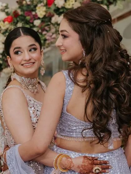 A lovely moment between sisters. Both have beautiful hairstyles, with the bride's soft waves looking particularly romantic.
