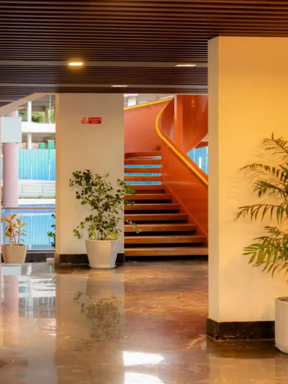 From the clubhouse lobby, the spiral staircase is glimpsed in the background, drawing the eye and inviting movement. Its placement ensures it is a central feature from multiple viewpoints.