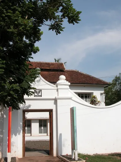 The entrance gate to the restored 1740 Dutch house in Fort Kochi. The clean white walls and the historic curved pediment signal the building's heritage, a project of careful conservation and adaptation.