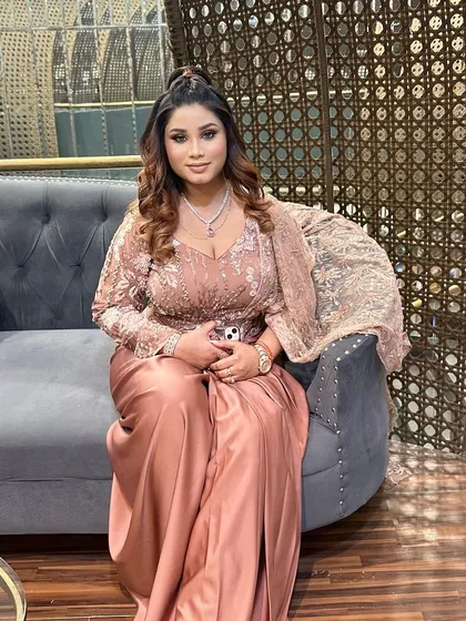 A lovely party look for an evening function. The client's makeup is soft and glowing, with a focus on shimmery eyes and a high ponytail, complementing her dusty rose satin gown.