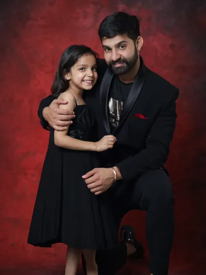 A sweet father-daughter moment. His gentle hug and her bright smile make this a truly heartwarming portrait.