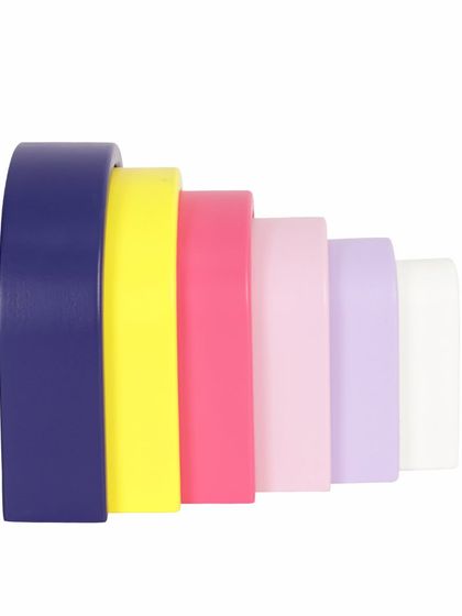 A side view of a nested wooden pastel arch toy, showing the gradient of colors.