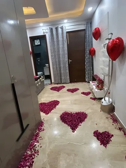 This view shows the pathway of rose petal hearts leading towards the decorated bed, creating a romantic trail for your loved one to follow.