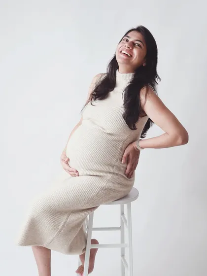 The pure joy of a mother to be. This solo portrait on a clean, white backdrop is all about celebrating your radiant pregnancy glow and the happiness that shines from within.